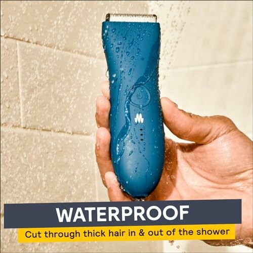 Hand holding a waterproof electric hair trimmer in the shower.